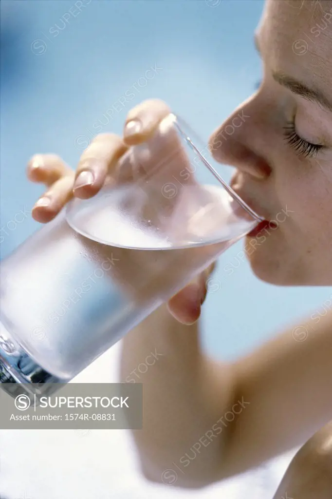 Close-up of a young woman drinking a glass of water