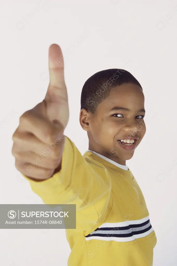 Portrait of a boy showing a thumb's up sign