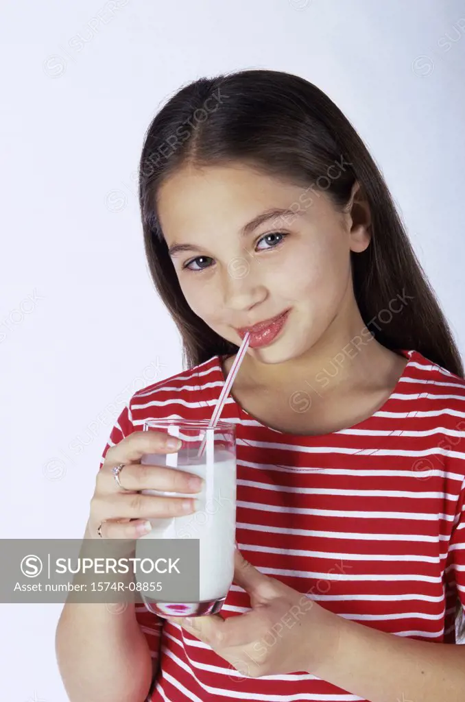 Portrait of a girl drinking milk with a straw