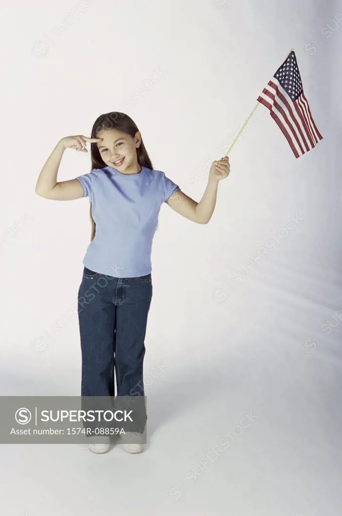 Portrait of a girl holding an American flag and saluting