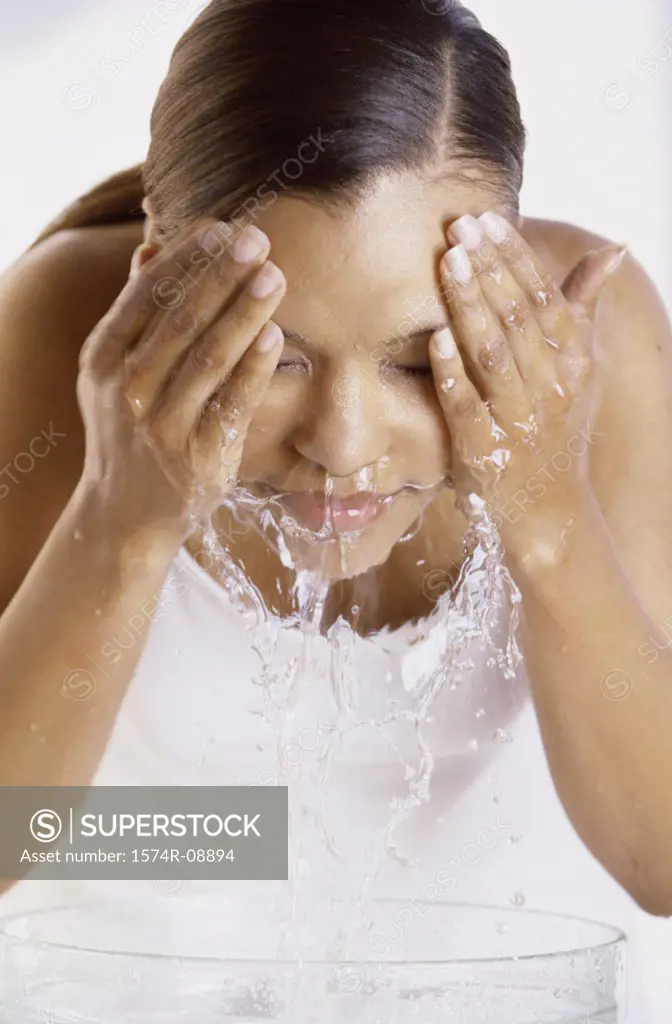Young woman washing her face