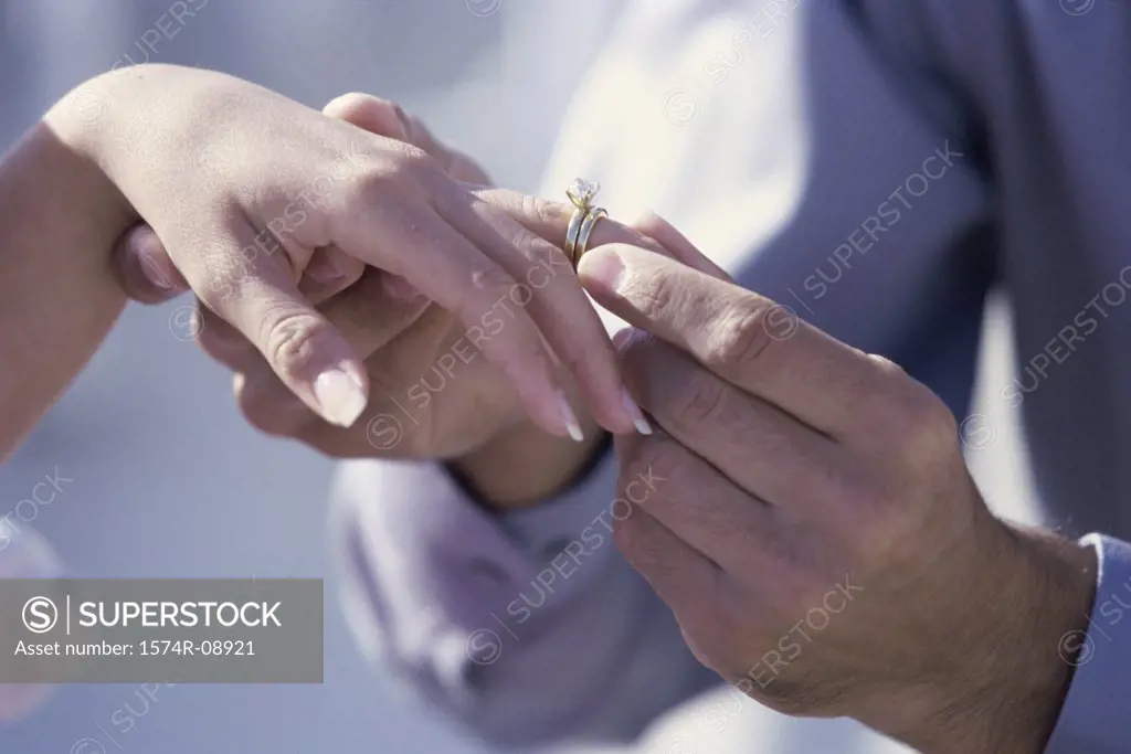 Close-up of a man putting a ring on a woman's finger