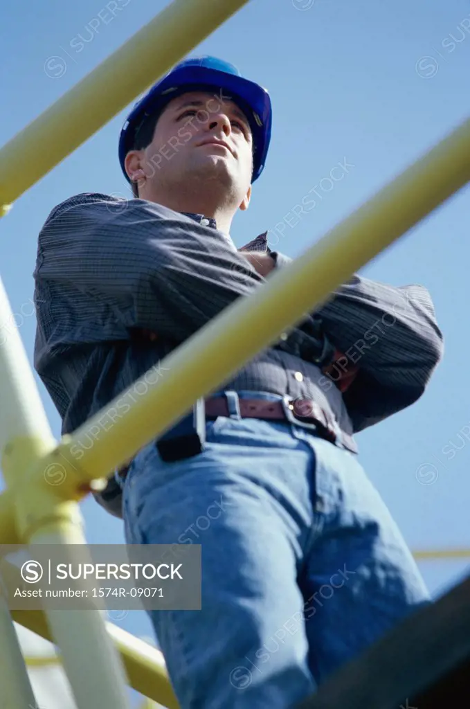 Low angle view of a construction worker standing with arms folded