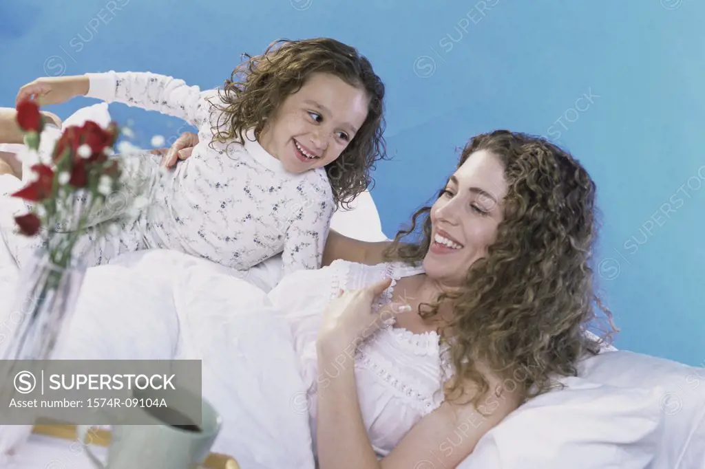 Mother and daughter in bed together with a breakfast tray