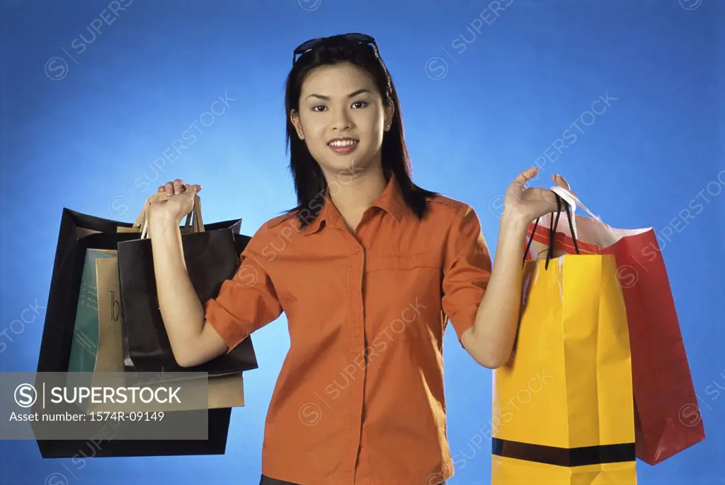 Portrait of a young woman carrying shopping bags