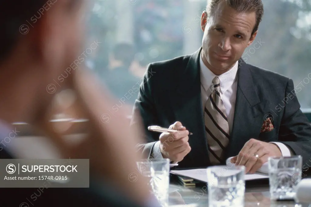 Businessman seated at a table signing a document