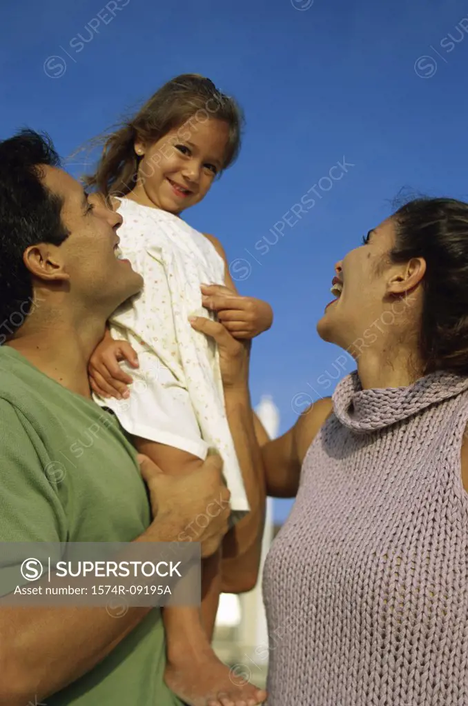 Low angle view of a mother and father with their daughter