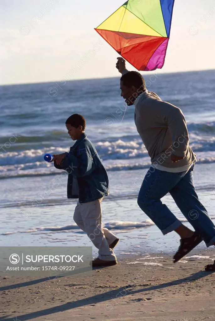 Father and son flying a kite on the beach