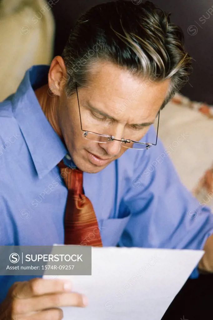 Close-up of a businessman reading a sheet of paper