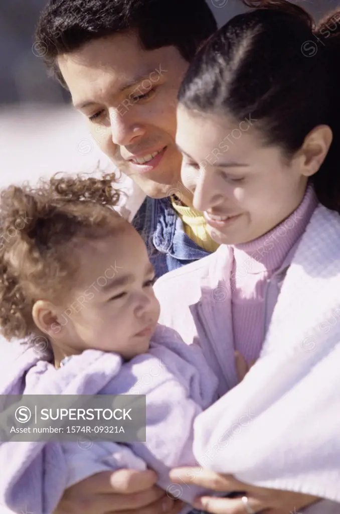 Close-up of a mother and father with their daughter