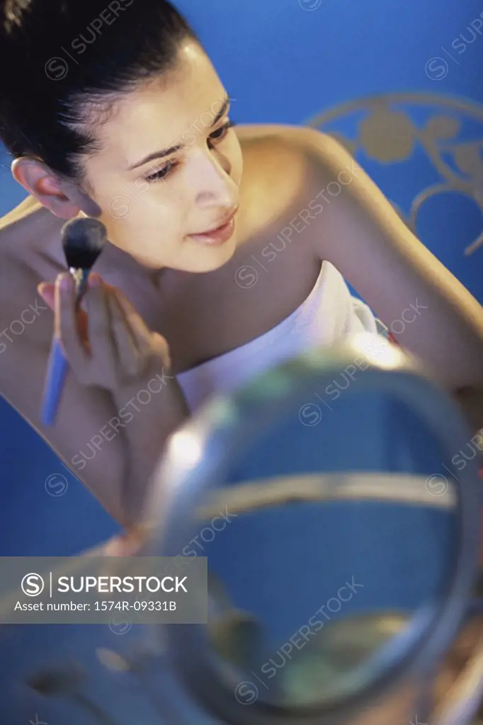 High angle view of a young woman applying make-up