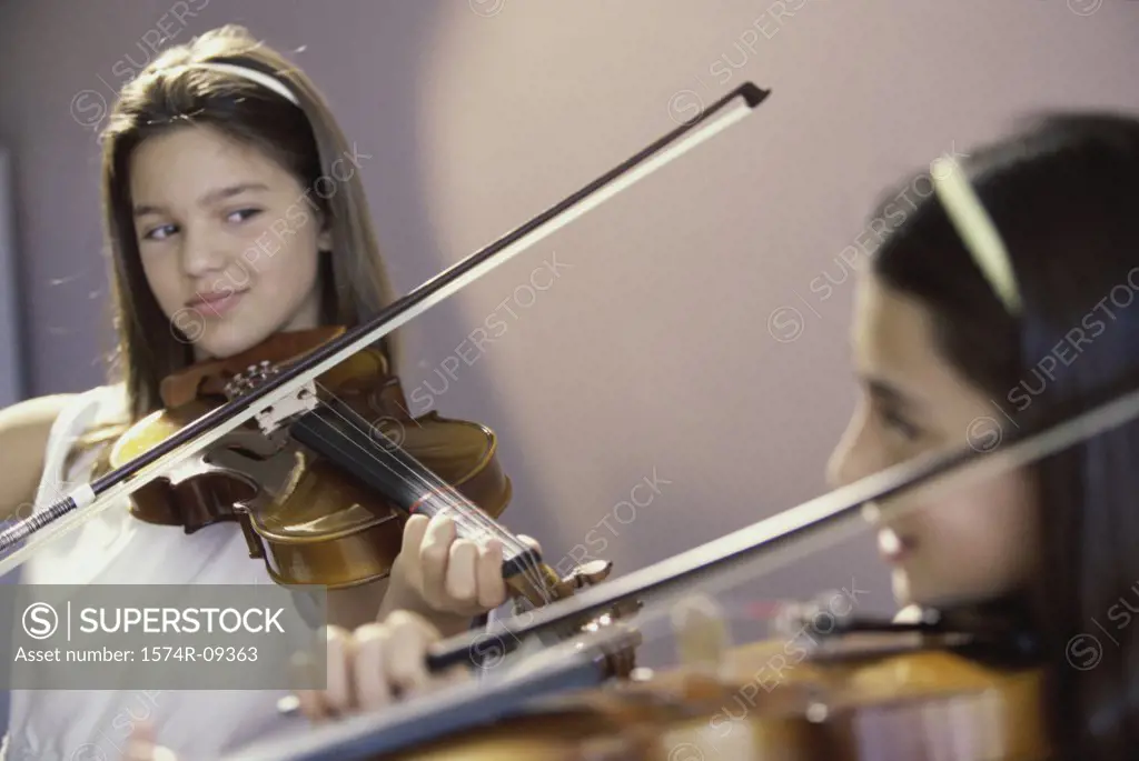 Two girls playing the violin