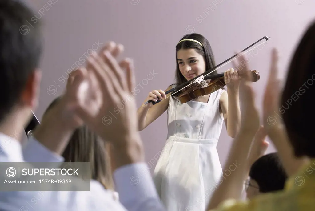 Girl playing a violin in front of an audience
