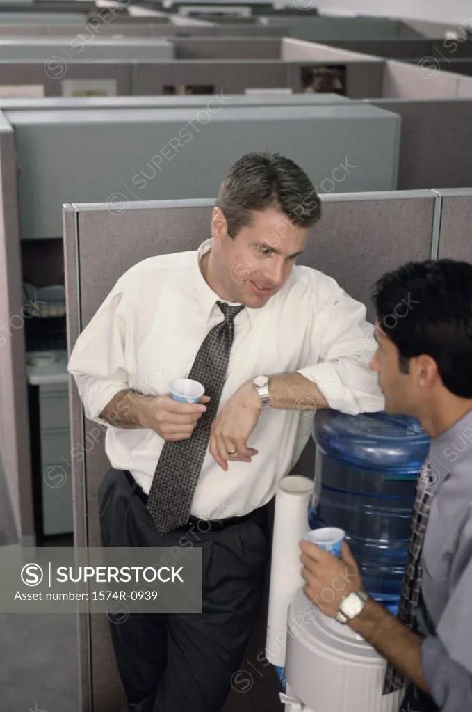 Two business executives talking at a water cooler