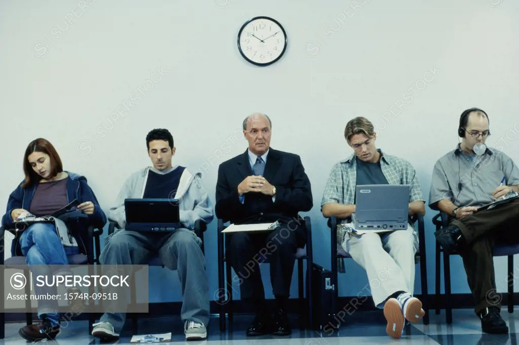 Business executives sitting in a row operating laptops