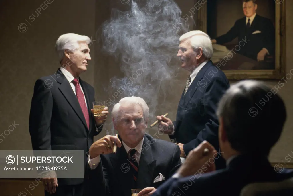 Businessmen drinking and smoking cigars in an office