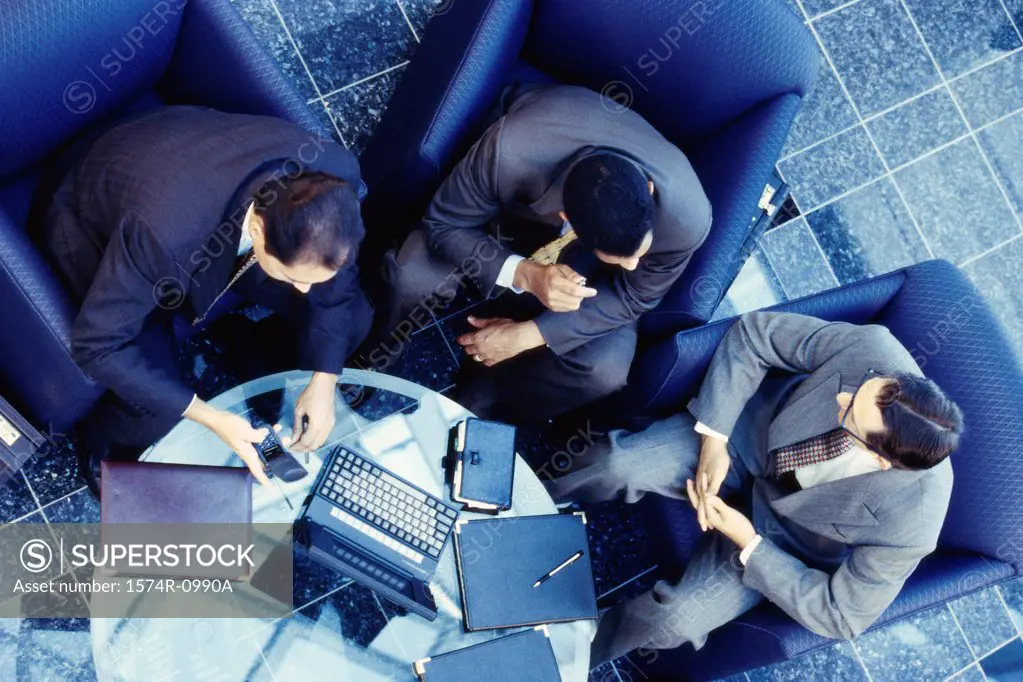 High angle view of three businessmen sitting on couches