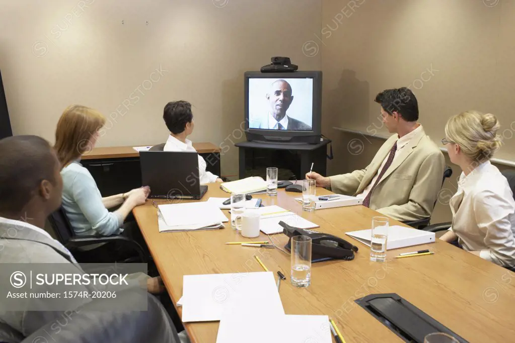 Business executives looking at the television in a video conference