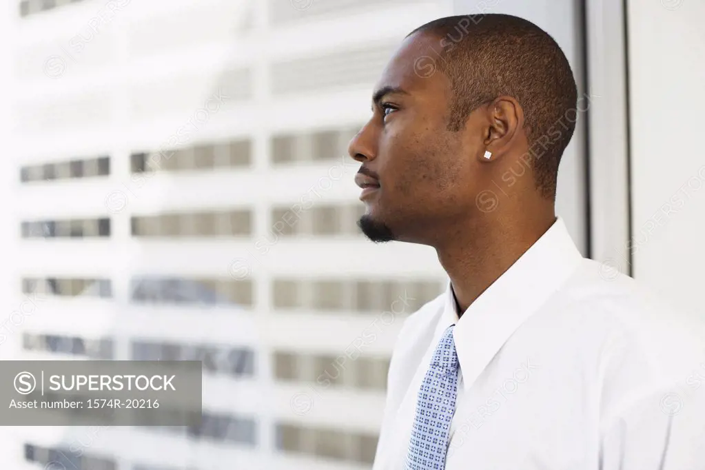 Side profile of a businessman looking through a window