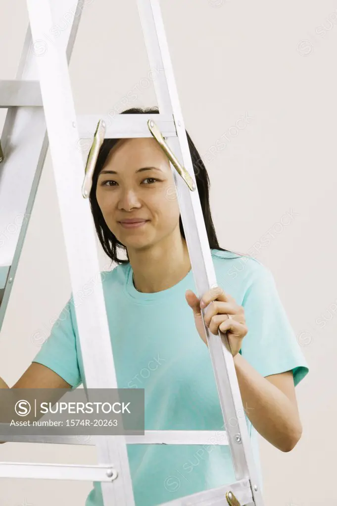 Portrait of a young woman holding a ladder