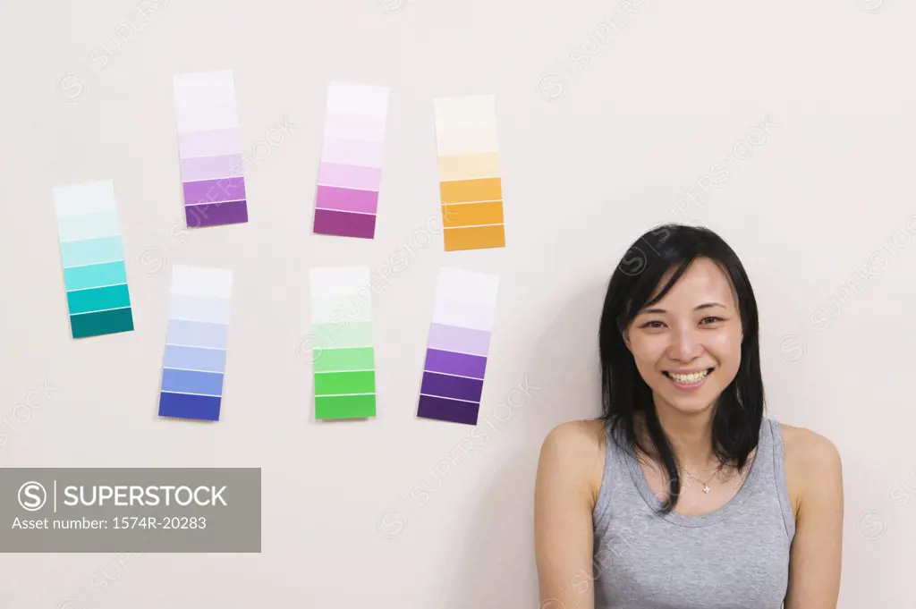 Close-up of a young woman smiling with color swatches on a wall
