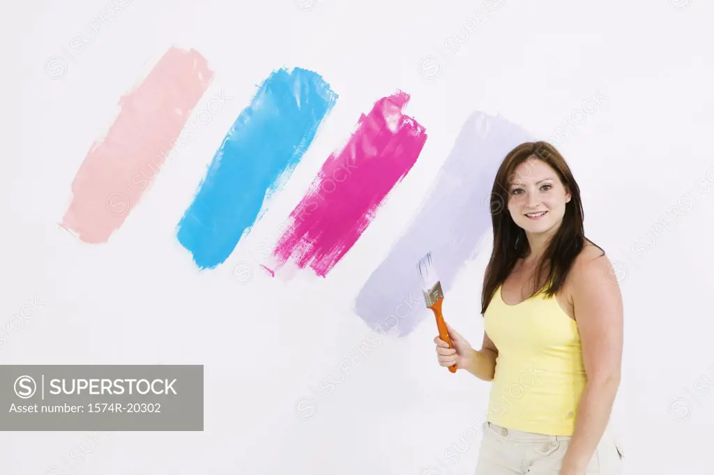 Portrait of a young woman holding a paintbrush