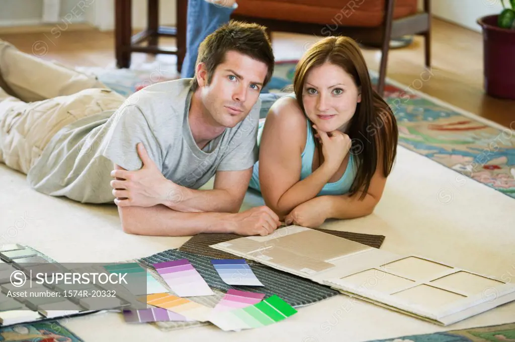 Portrait of a young couple lying down with color swatches in front of them