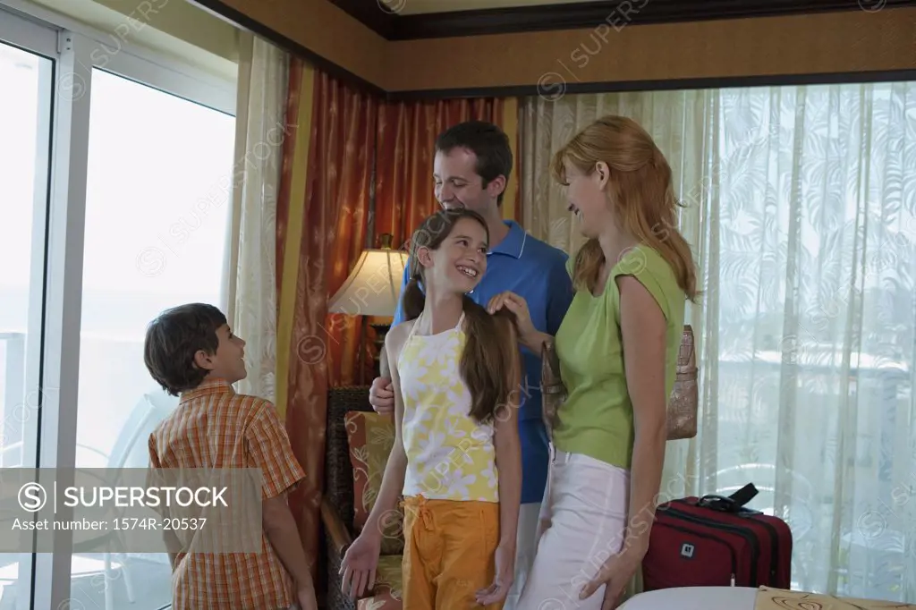 Young couple standing with their son and daughter in a hotel room