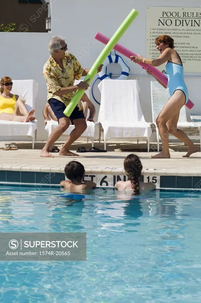 Side profile of a senior couple playing at poolside