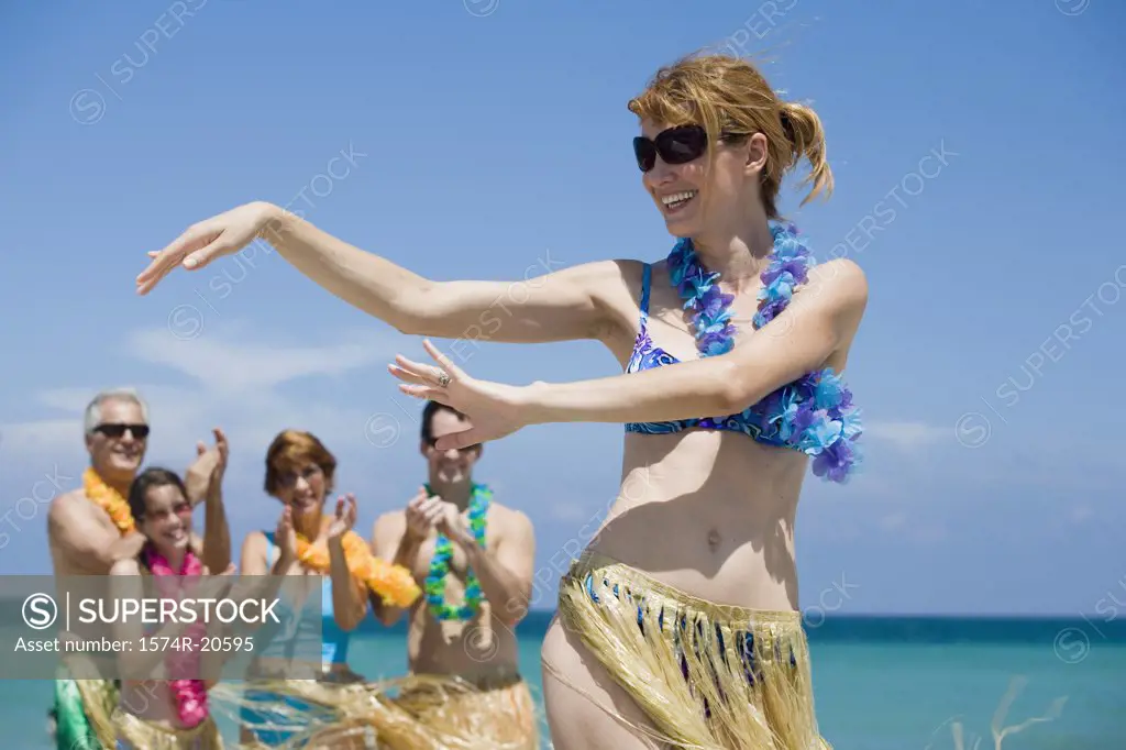 Close-up of a young woman hula dancing on the beach