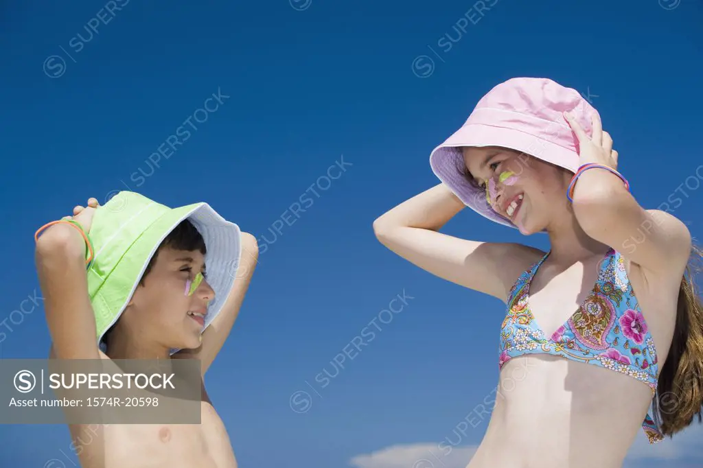 Side profile of a boy and his sister looking at each other and smiling