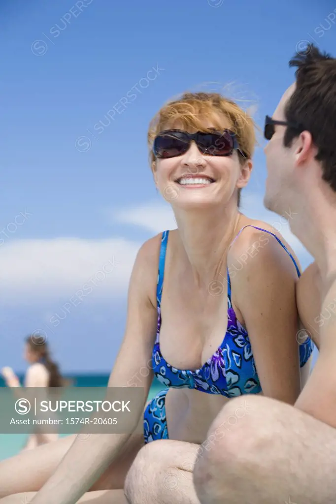 Side profile of a young couple sitting on the beach