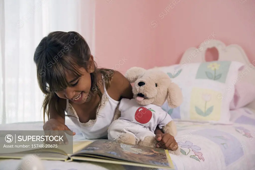 Close-up of a girl lying in the bed and looking at a picture book