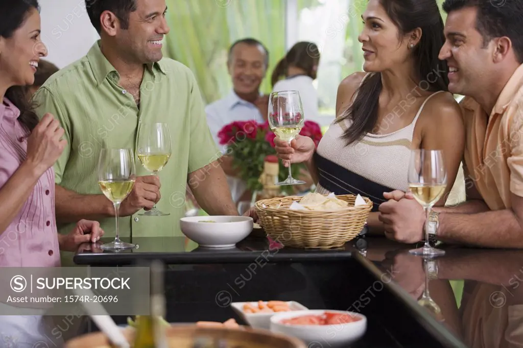 Close-up of a mature couple and a mid adult couple looking at each other and smiling