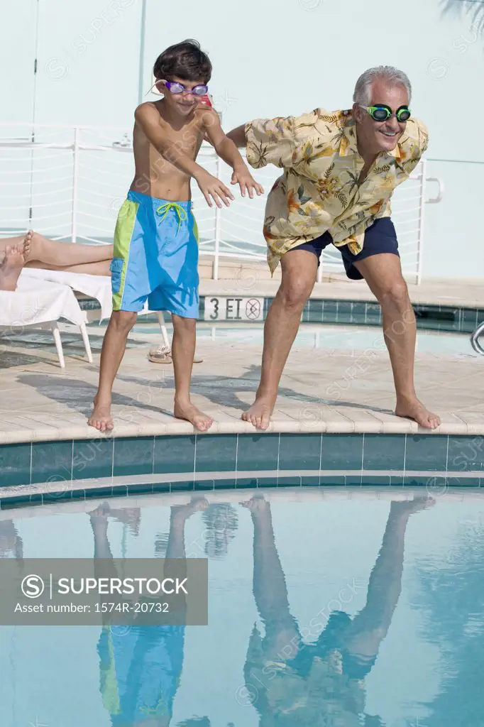 Senior man teaching his grandson to swim at poolside