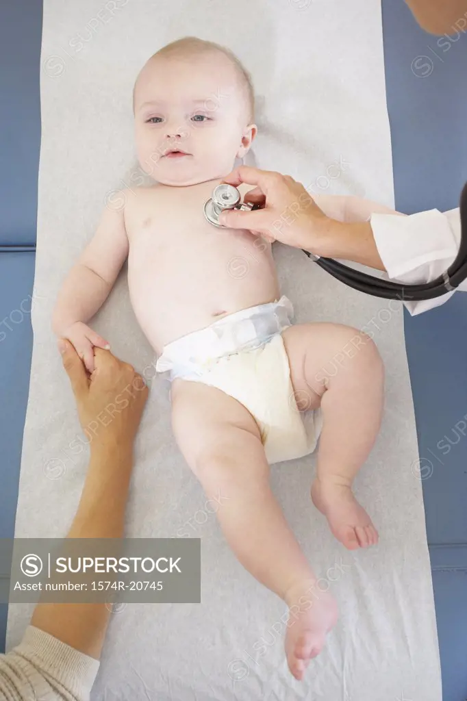 High angle view of a female doctor examining a baby boy with a stethoscope
