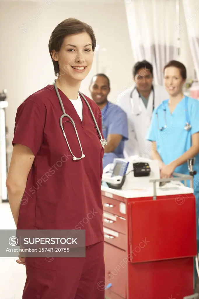 Female doctor smiling with her colleagues in the background