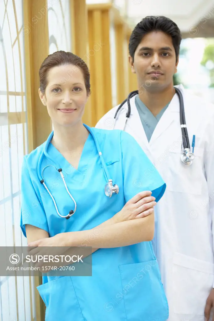 Female doctor smiling and a male doctor standing behind her