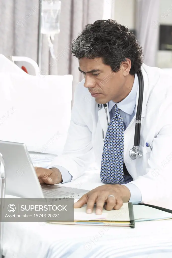 Side profile of a male doctor using a laptop
