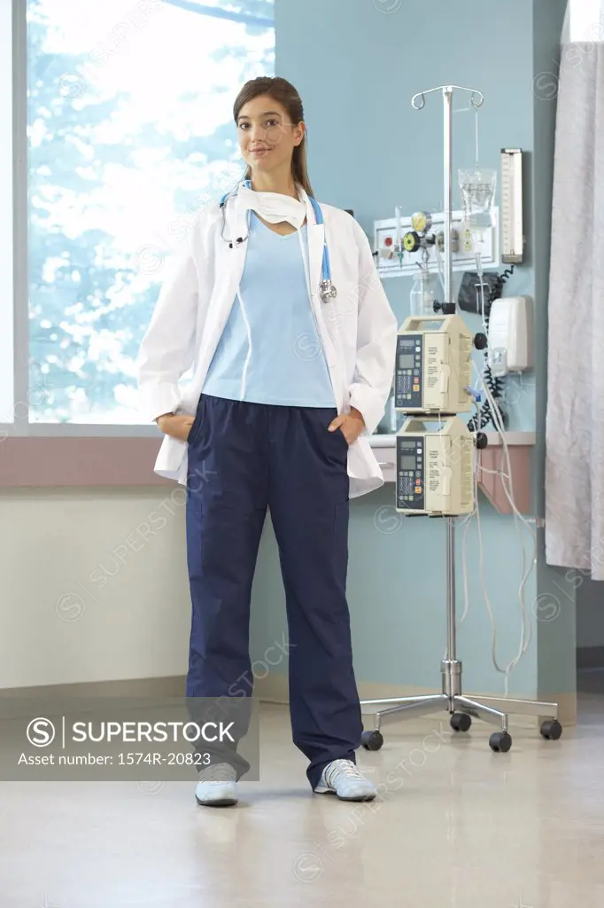 Portrait of a female doctor standing near an IV drip stand