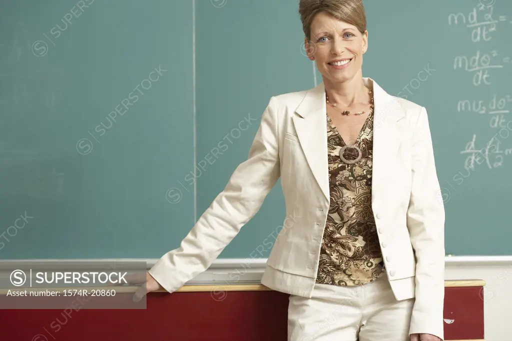 Female professor standing in front of a blackboard and smiling