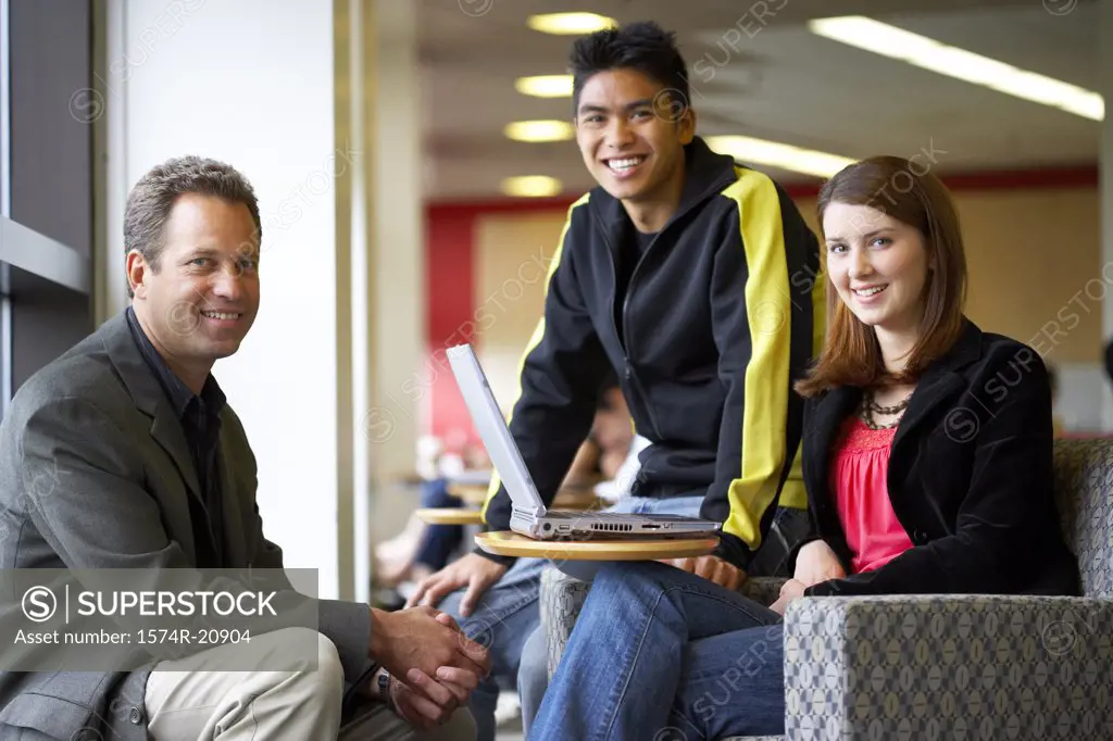 Male professor sitting with his students and smiling