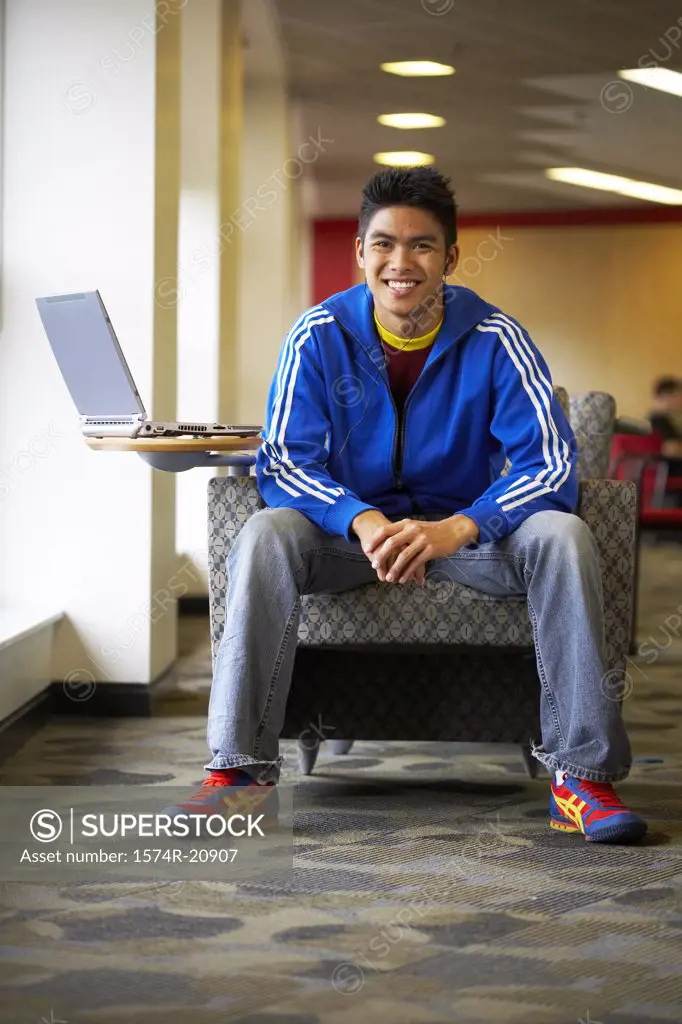 College student sitting in an armchair and smiling