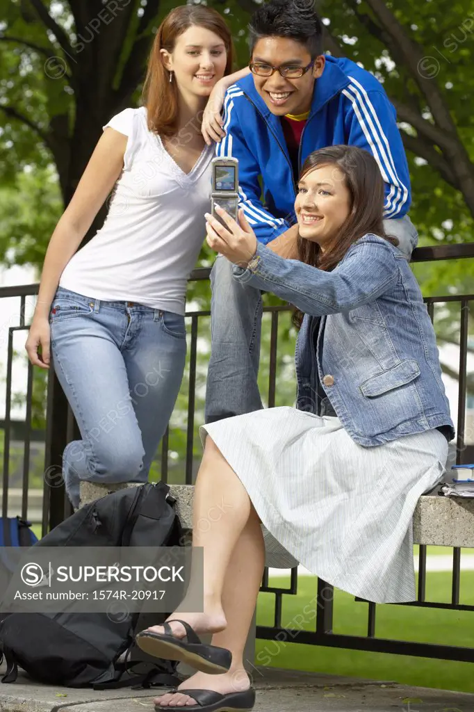 Three college students taking their picture with a mobile phone