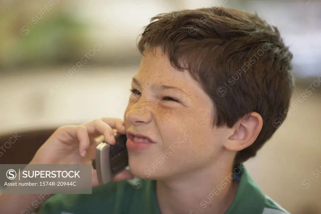 Close-up of a boy using a mobile phone and making a face