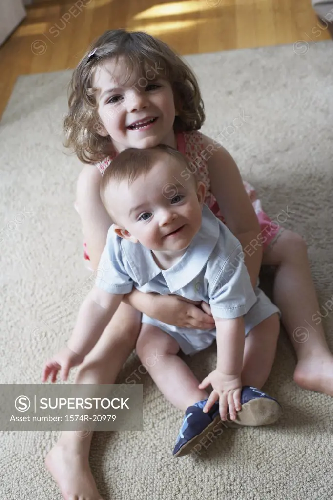 High angle view of a girl hugging her brother and smiling