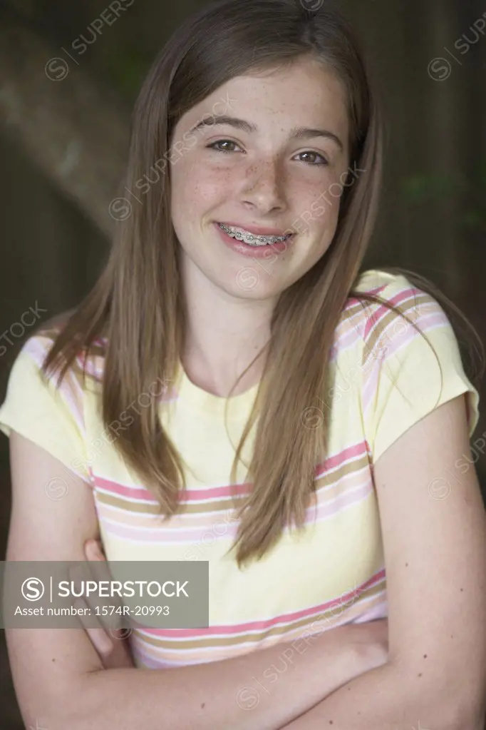 Portrait of a teenage girl smiling with her arms crossed