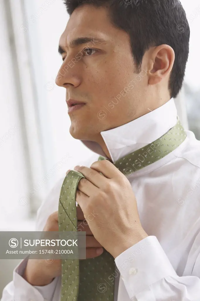 Side profile of a businessman tying his tie