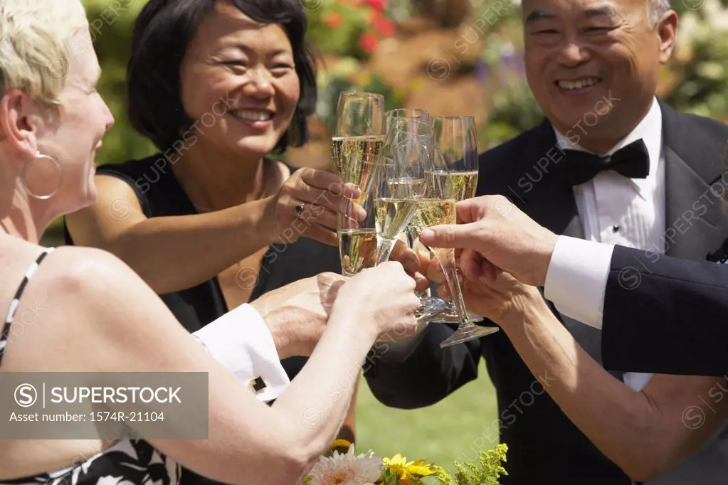 Close-up of mature couples toasting with champagne flutes