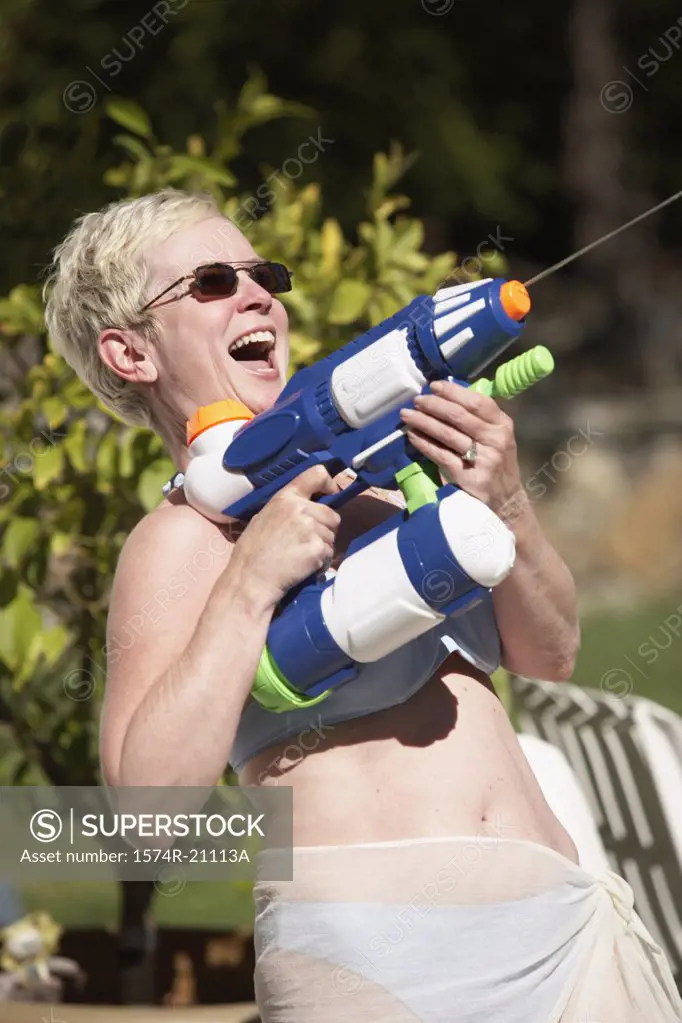 Close-up of a mature woman spraying water with a squirt gun